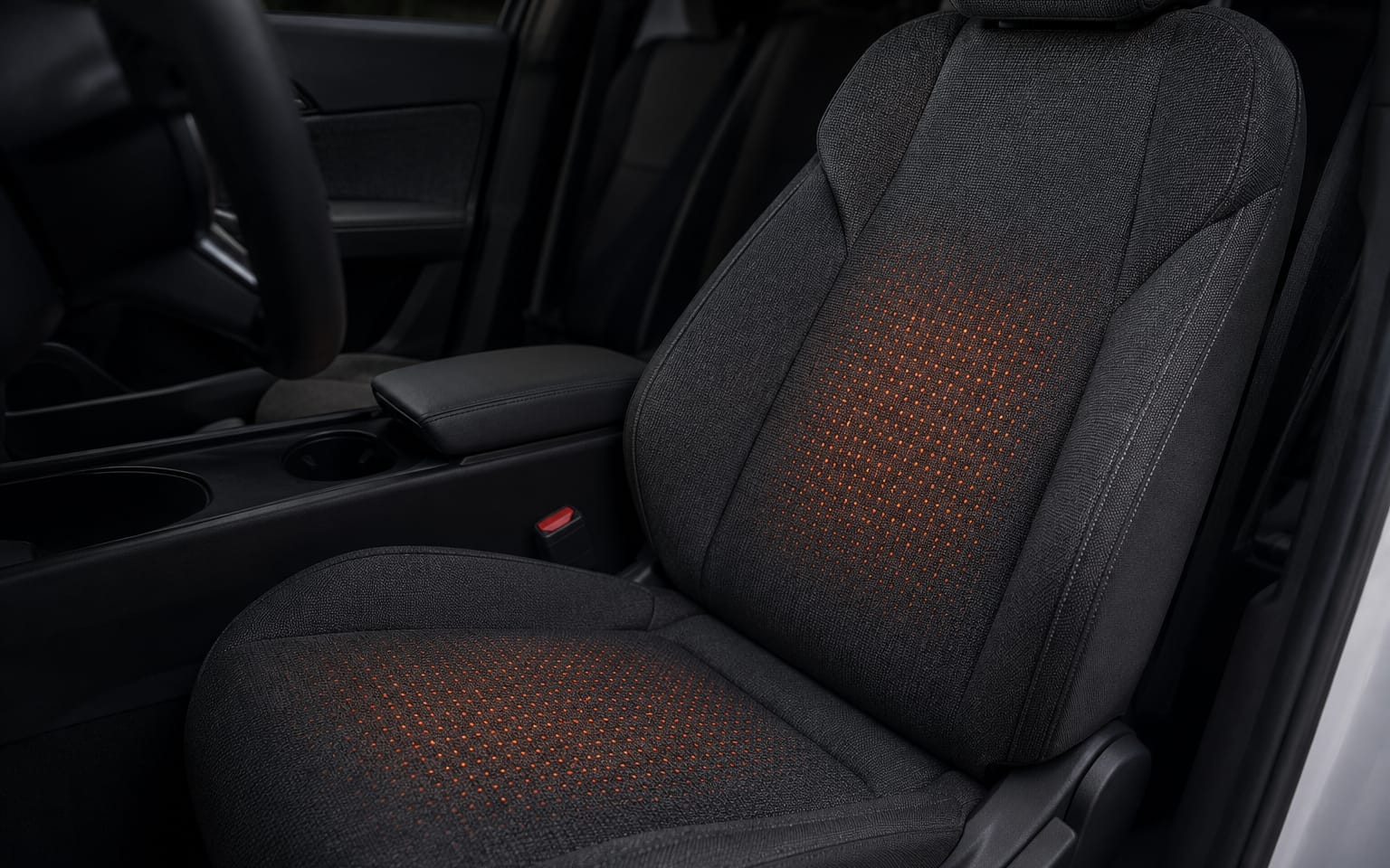 A seat with knitted heat zones reading as soft warm glows