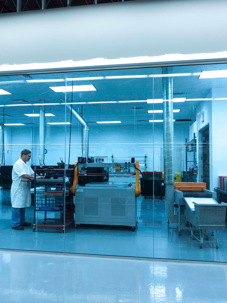 A technician at work inside the glass-walled clean lab