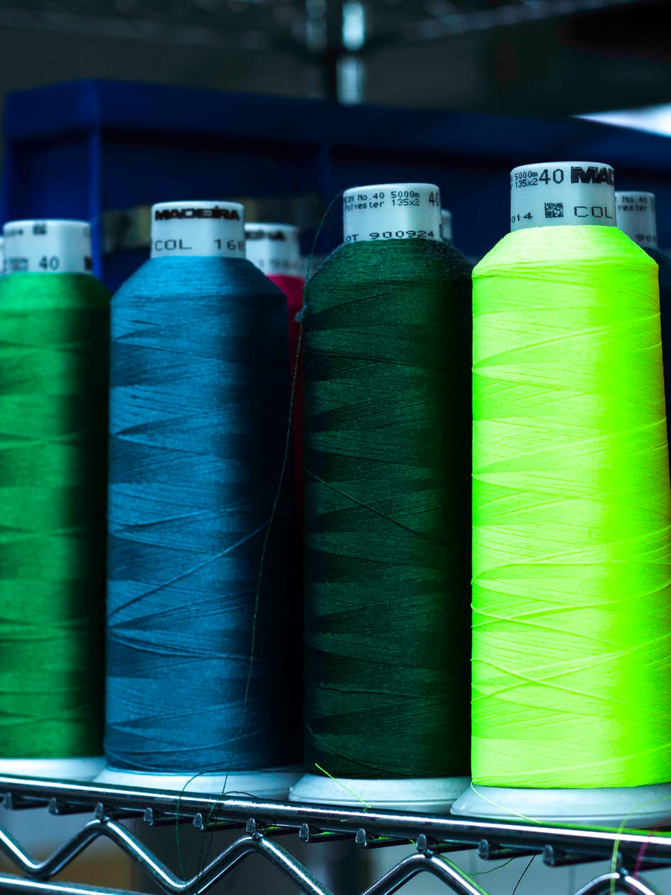 Cones of conductive and technical yarn racked on the floor