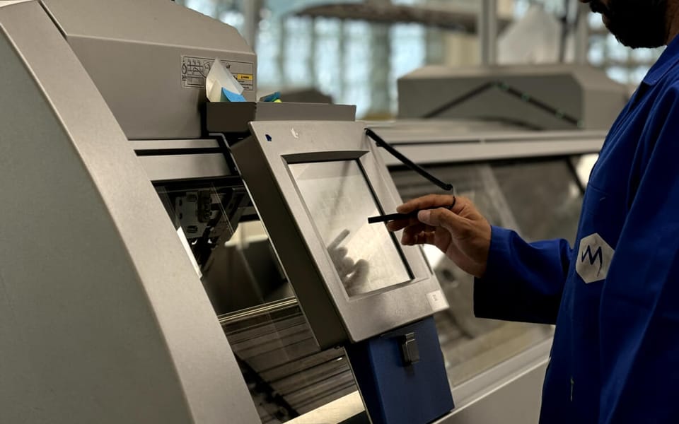 A MyantX engineer at an industrial knitting machine control panel