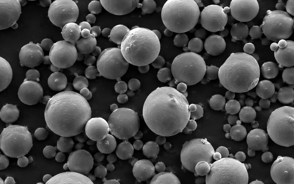 Engineered polymer particles at high magnification — near-spherical and tightly distributed