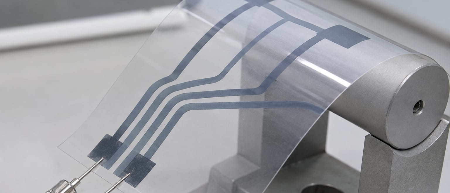 Printed conductive traces on a clear flexible film under test probes