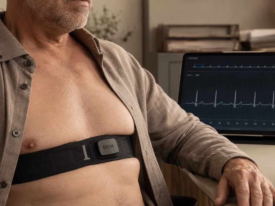 A knitted SKIIN chest band reading live ECG, with the trace on a tablet alongside