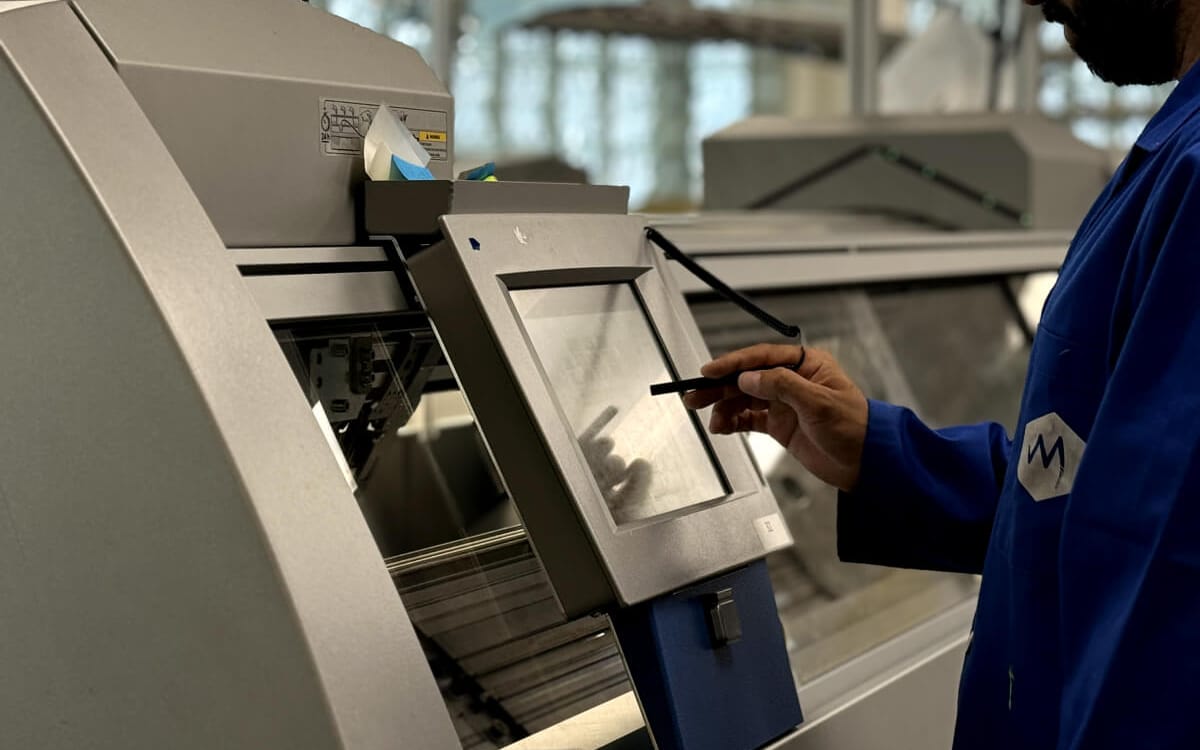 A MyantX engineer at an industrial knitting machine control panel